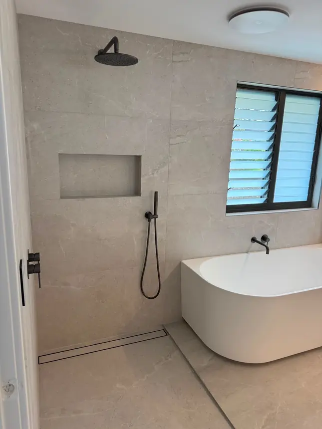 The finished bathroom with a freestanding bath, walk-in shower and black tapware