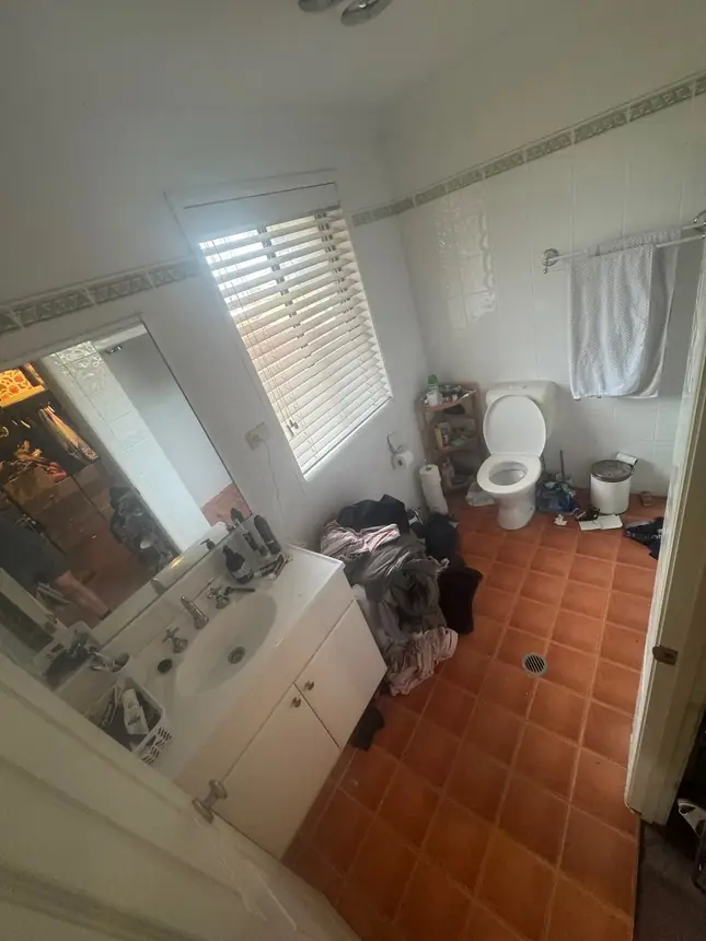 The original bathroom before renovation — terracotta floor tiles and a dated vanity