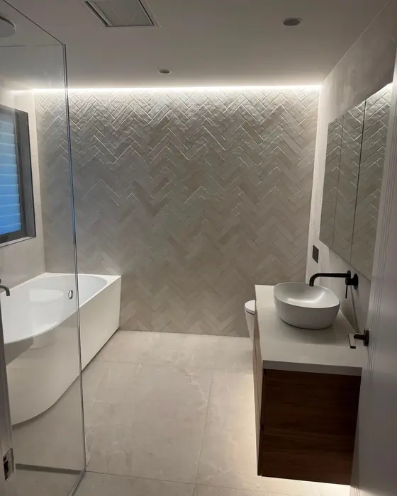 Finished bathroom with a freestanding bath and herringbone feature wall