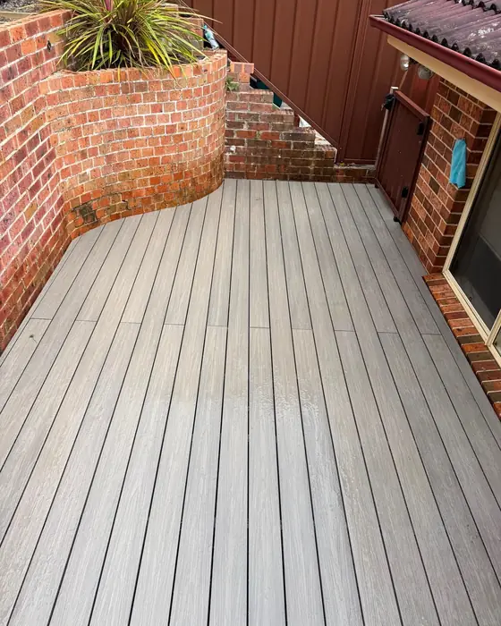 Composite deck running the length of a courtyard between brick walls