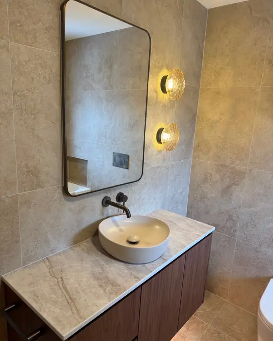 Vanity with a stone top, vessel basin and wall lights