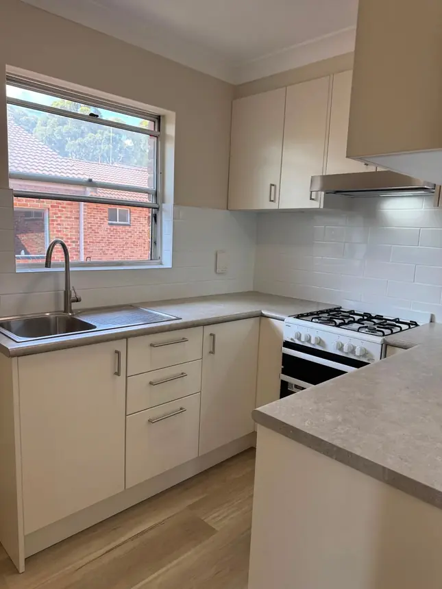 The finished kitchen with new cabinetry, stone benchtop and a gas cooktop